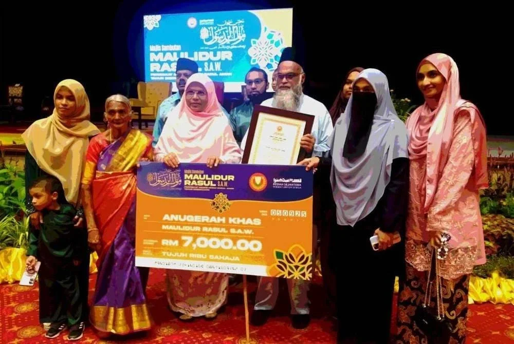 Mohd Naim (tiga dari kanan) bersama ibunya, S Subbamah, 78 (dua dari kiri) serta ahli keluarga selepas menerima anugerah sempena Maulidur Rasul peringkat negeri pada Jumaat.