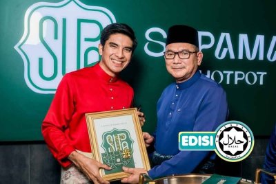 AZMI (kanan) menyampaikan cenderahati kepada Syed Saddiq pada majlis perasmian restoran Supamala di Bangsar baru-baru ini. Foto Supamala