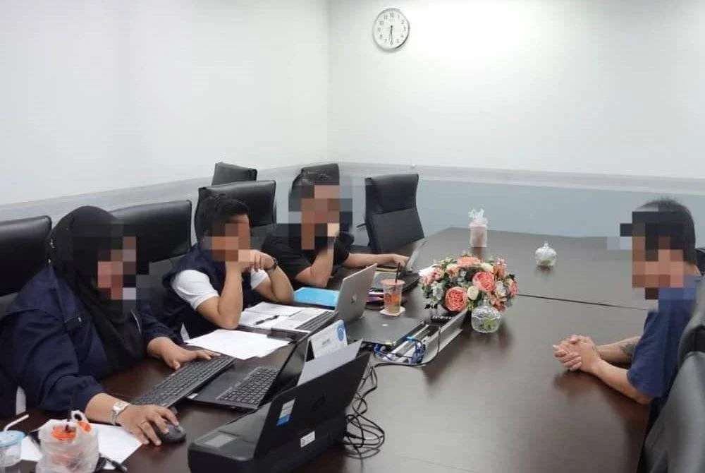 SKMM merekod keterangan individu yang ditahan untuk membantu siasatan kes sindiket penyebaran SMS. Foto SKMM