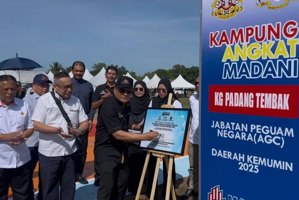 Mohd Dusuki menandatangani plak perasmian Majlis Penyerahan Infrastruktur Awam, Program Kampung Angkat Madani, Jabatan Peguam Negara 2025 di Kampung Padang Tembak, Kota Bahru pada Sabtu.
