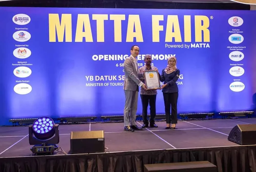 Nigel (kiri) dan Surrendren ketika menerima sijil Malaysia Book of Record bagai pameran pelancongan antarabangsa terbesar di negara ini ketika majlis perasmian MATTA Fair ke-57 di Mitec pada Sabtu.
