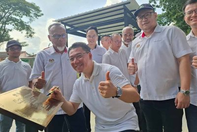 Kor Ming menandatangani plak perasmian Taman Rekreasi Madani Taman Westpool di Kepayang, Ipoh pada Sabtu.