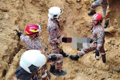 Pasukan bomba melakukan kerja mengeluarkan mangsa yang tertimbus dalam runtuhan tanah di kawasan UMS, Kota Kinabalu pada Sabtu. Foto: JBPM Sabah