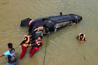 Dua beradik lelaki dan perempuan ditemukan lemas manakala ibu dan bapanya terselamat selepas kereta yang berada dalam keadaan parkir tergelongsor jatuh ke dalam sungai - Foto: Bernama