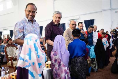 Ahmad Zahid (dua dari kiri) bersama Zambry bersalaman bersama murid-murid Kemas pada Program Mode Kemas dan Bakti Madani UiTM di Dewan Masjid Tuminah Hamidi, Bagan Datuk pada Ahad. 