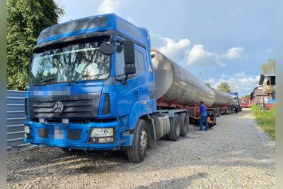 Anggota penguat kuasa memeriksa lori tanker yang digunakan bagi memindahkan minyak sawit secara haram.