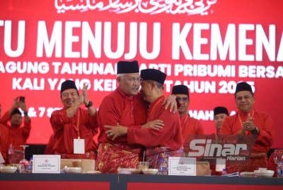 Muhyiddin (kanan) berpelukan dengan Hamzah ketika sesi menggulung ucapan dasar presiden sempena PAT Bersatu ke-8 di IDCC Shah Alam pada Ahad. Foto Sinar Harian ASRIL ASWANDI SHUKOR