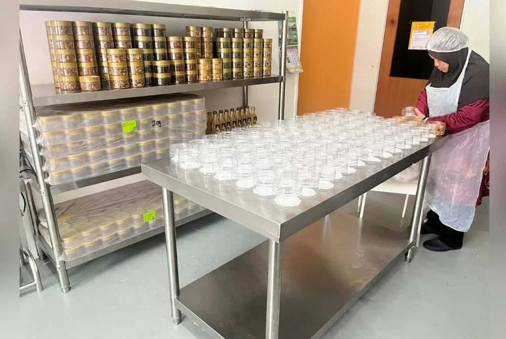 Pekerja sibuk mengisi Pegaga Crispy ke dalam bekas sebelum ia dipasarkan.