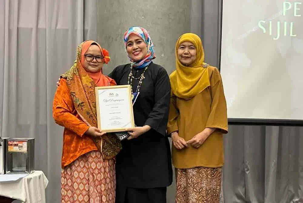 Tengku Khalidah (tengah) diiringi Nora (kanan) menyampaikan sijil penghargaan kepada Ketua Biro Sinar Harian Kelantan, Hazelen Liana Kamarudin (kiri). 
FOTO SINAR HARIAN - ADILA SHARINNI WAHID