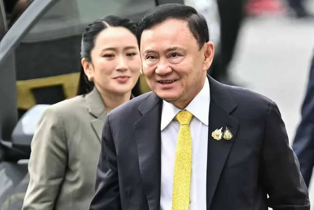Thaksin diiringi Paetongtarn ketika hadir di mahkamah pada Selasa. - Foto AFP