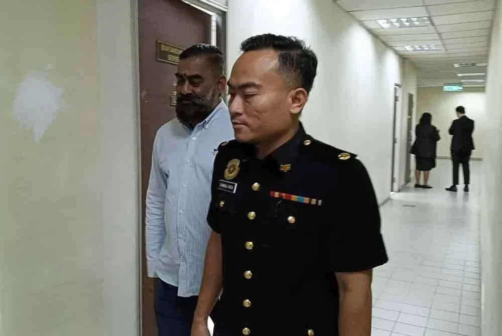 Tertuduh diiringi pegawai SPRM ketika dibawa ke Mahkamah Butterworth pada Selasa.