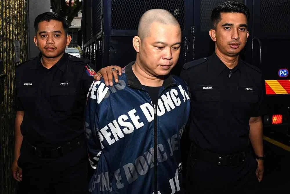 Tertuduh (tengah) dibawa keluar dari Mahkamah Majistret Butterworth selepas dijatuhi hukuman pada Selasa. - Foto: Bernama