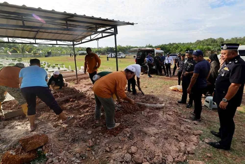 Seorang individu yang berada di lokasi kejadian, Ade Mos, 47, membantu proses pengebumian semasa hadir bagi memberi penghormatan terakhir kepada dua jenazah beradik yang lemas di Sungai Tanjung Agas, Linggi pada 4 September, di Tanah Perkuburan Maqbarah Salimah, Taman Intan Perdana kira-kira 5.30 petang tadi.
