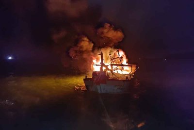 Sebuah bot nelayan musnah 80 peratus selepas terbakar di perairan Pantai Remis di Lumut pada malam Isnin. Foto: Ihsan Bomba Perak