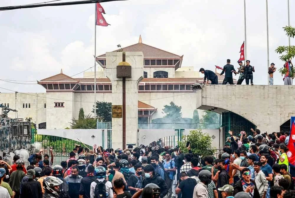 Penunjuk perasaan mengibarkan bendera Nepal ketika berhimpun di luar bangunan Parlimen, di Kathmandu. Foto AFP