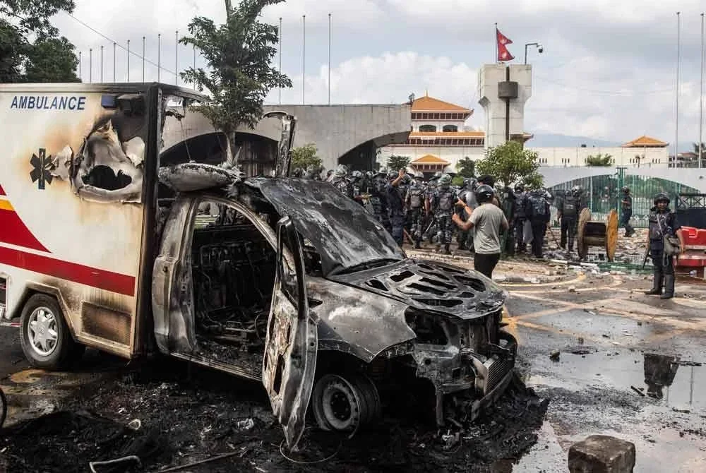Sebuah ambulans yang hangus terbakar ketika protes di luar bangunan Parlimen. Foto AFP