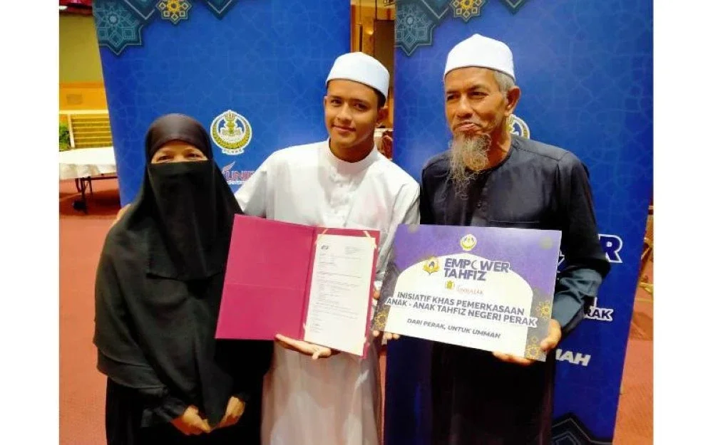 Abdul Mu'izz (tengah) bersama ibu bapanya menunjukkan surat tawaran yang diterima.