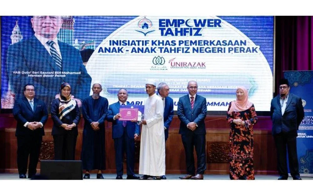 Abdul Mui'zz (lima dari kiri) menerima dokumen tawaran melanjutkan pengajian daripada Saarani (empat dari kiri) sempena program Empower Tahfiz Inisiatif Khas Pemerkasaan Anak-Anak Tahfiz Negeri Perak yang diadakan di Ipoh, baru-baru ini.