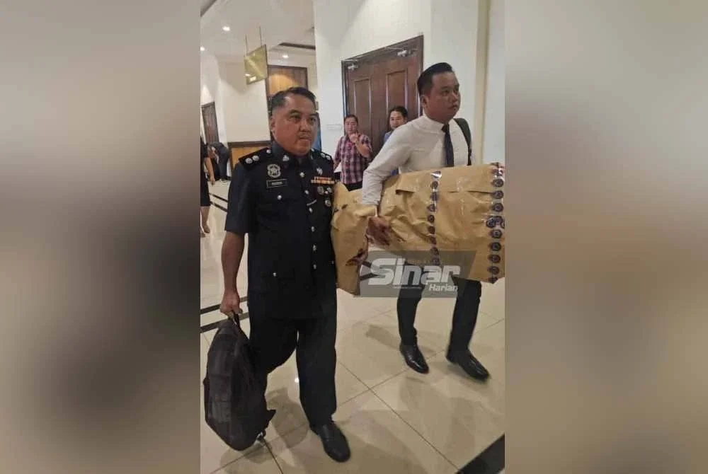 Patung yang digunakan dalam simulasi yang dipaparkan melalui dua video dimainkan di Mahkamah Koroner pada Selasa, dibawa oleh saksi kelima, Inspektor Maidon Bernados (kiri). Foto Sinar Harian ASYIKIN ASMIN