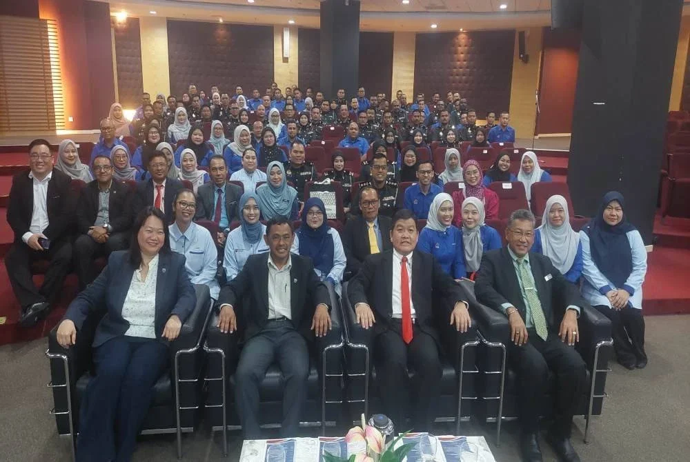 Loy Sian (depan, dua dari kanan) dan Khalid (kanan) bergambar bersama warga kerja SWCorp yang akan mengikuti Program Diploma Eksekutif Pengurusan Penguatkuasaan Undang-undang dan Diploma Eksekutif Pengurusan (Pentadbiran dan Operasi) di Dewan Auditorium, UM pada Rabu.
