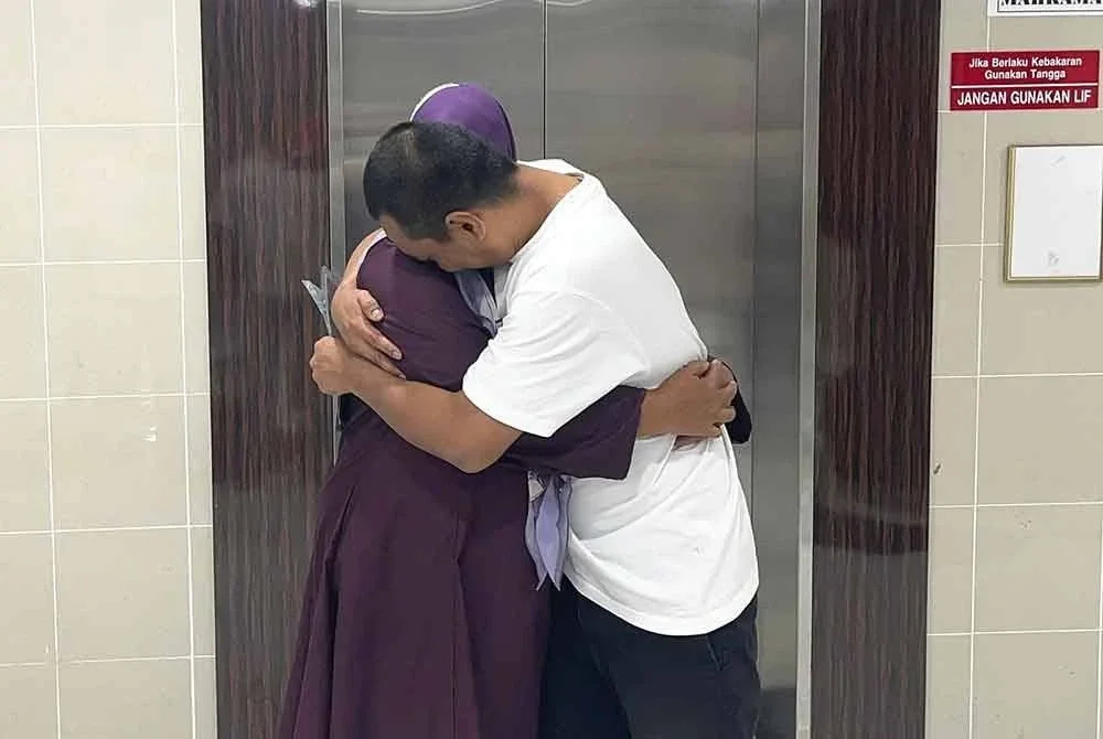 Mohd Faizal (kanan) memeluk erat ibunya sebaik dilepas dan dibebaskan daripada pertuduhan mengedar dadah tiga tahun lalu.