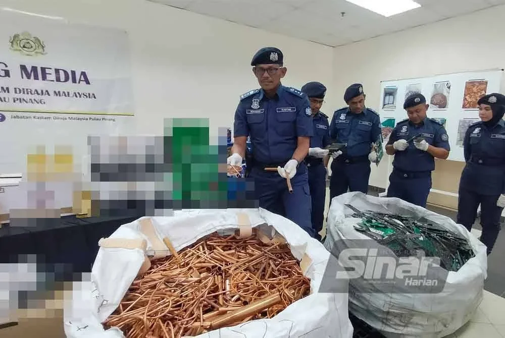 Rohaizad (kiri) menunjukkan copper scrap yang ditemui di dalam lima buah kontena di Pelabuhan NBCT pada 22 Julai lalu.