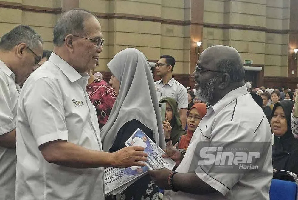 Wan Rosdy (kiri) menyampaikan insentif kepada salah seorang wakil pelajar cemerlang dalam Majlis Penyampaian Insentif SPM, STPM dan
STAM 2024 Negeri Pahang di Dewan Jubli Perak, Sultan Haji Ahmad Shah, Kuantan pada Rabu.