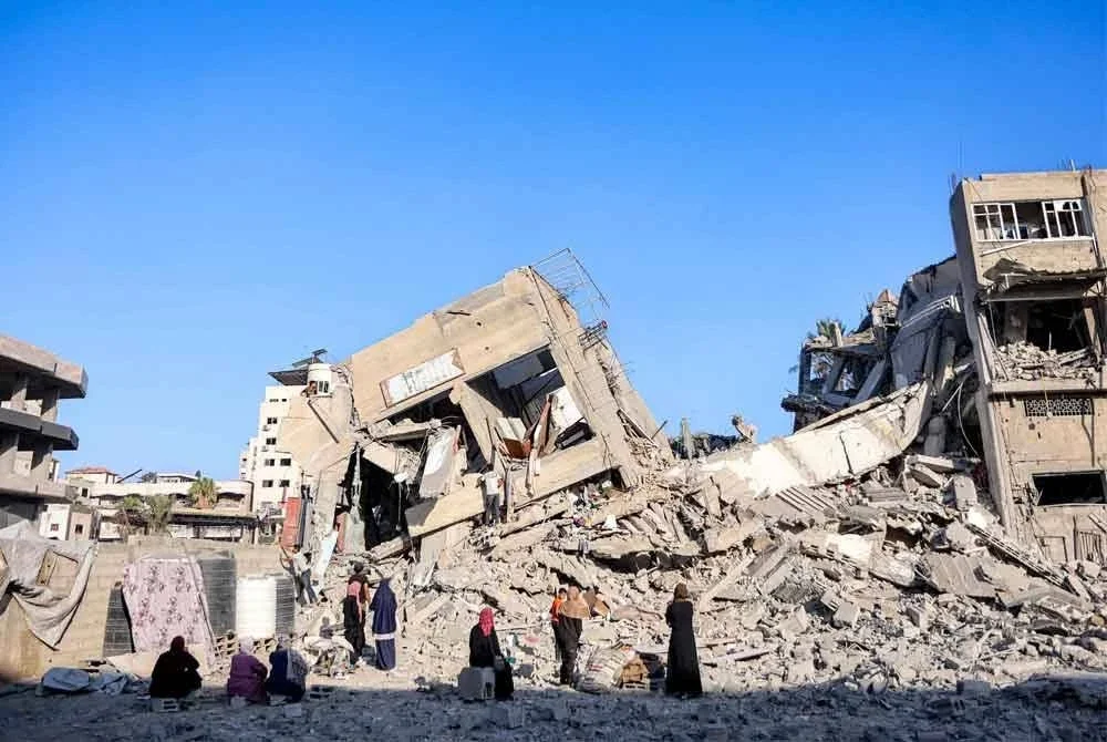 Orang ramai mencari barang-barang yang diselamatkan dari runtuhan Menara Salam, berikutan serangan Israel pada hari sebelumnya ke atas bangunan itu di Kota Gaza. Foto AFP