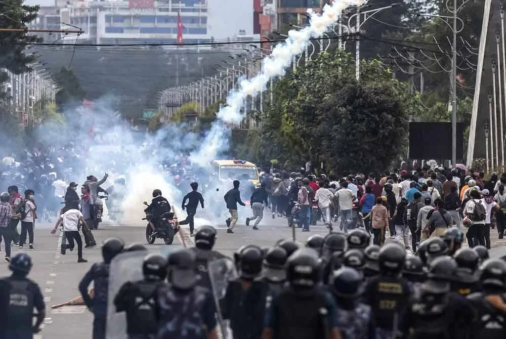 Anggota polis rusuhan melepaskan gas pemedih mata untuk menyuraikan penunjuk perasaan di hadapan bangunan Parlimen, Kathmandu pada 8 September 2025.
