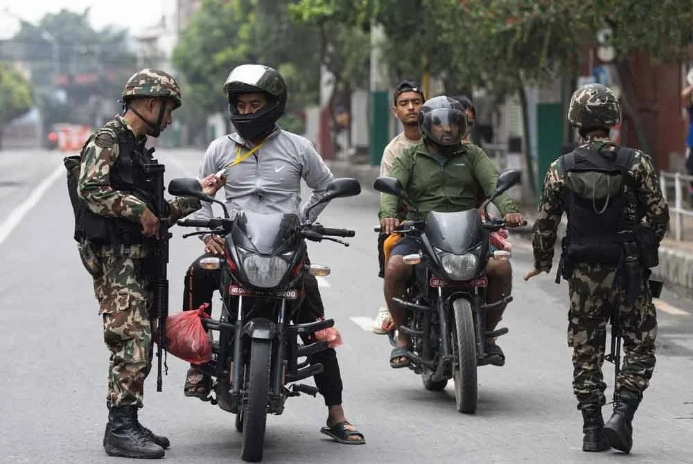 Anggota tentera memeriksa bukti identiti dan dokumen penumpang di sepanjang jalan sebagai sebahagian daripada langkah keselamatan yang dikenakan di Kathmandu pada 10 September. Foto AFP