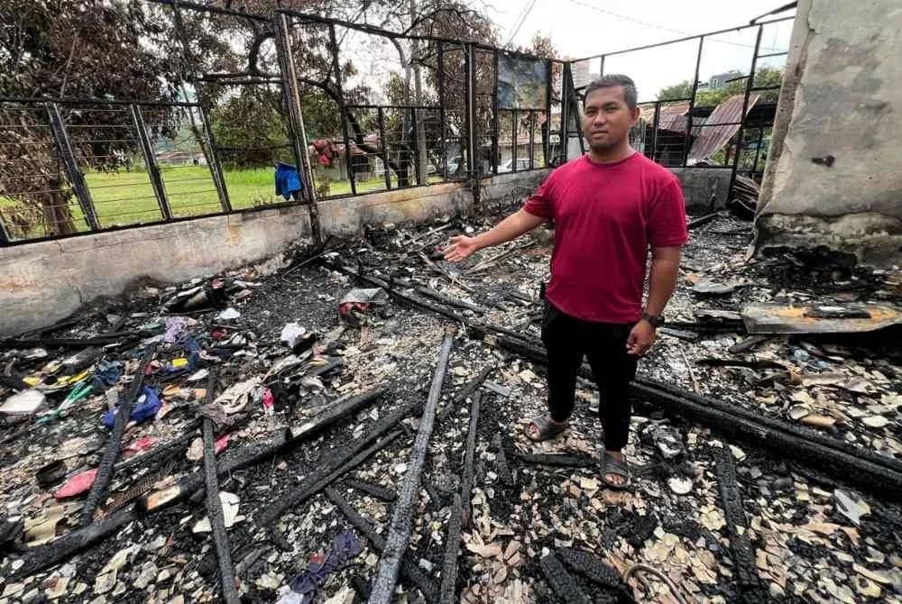 Airry Adzley menunjukkan kesan kebakaran yang memusnahkan rumahnya dalam kejadian pada Selasa.