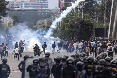 Anggota polis rusuhan melepaskan gas pemedih mata untuk menyuraikan penunjuk perasaan di hadapan bangunan Parlimen, Kathmandu pada 8 September 2025.