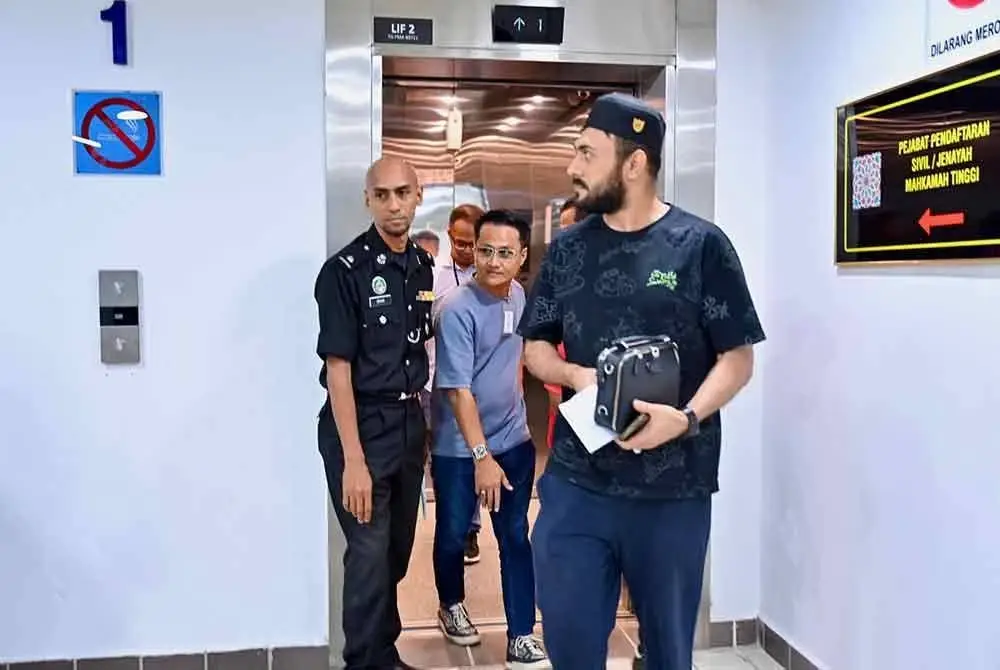 Mohd Fazlan (tengah) bersama pemilik syarikat berkenaan ketika dihadapkan di Mahkamah Sesyen Kuala Terengganu pada Khamis atas dua pertuduhan menggaji dan membenarkan pekerja asing tinggal tanpa pas atau permit yang sah.