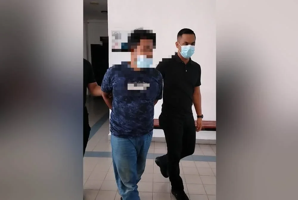 Tertuduh (kiri) dibawa keluar dari Mahkamah Sesyen 2 Sungai Petani pada Khamis.