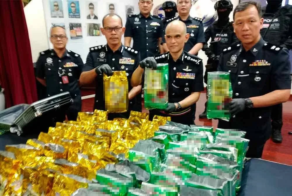 Shazeli (dua, kanan) menunjukkan dadah yang dirampas dalam operasi yang dijalankan.