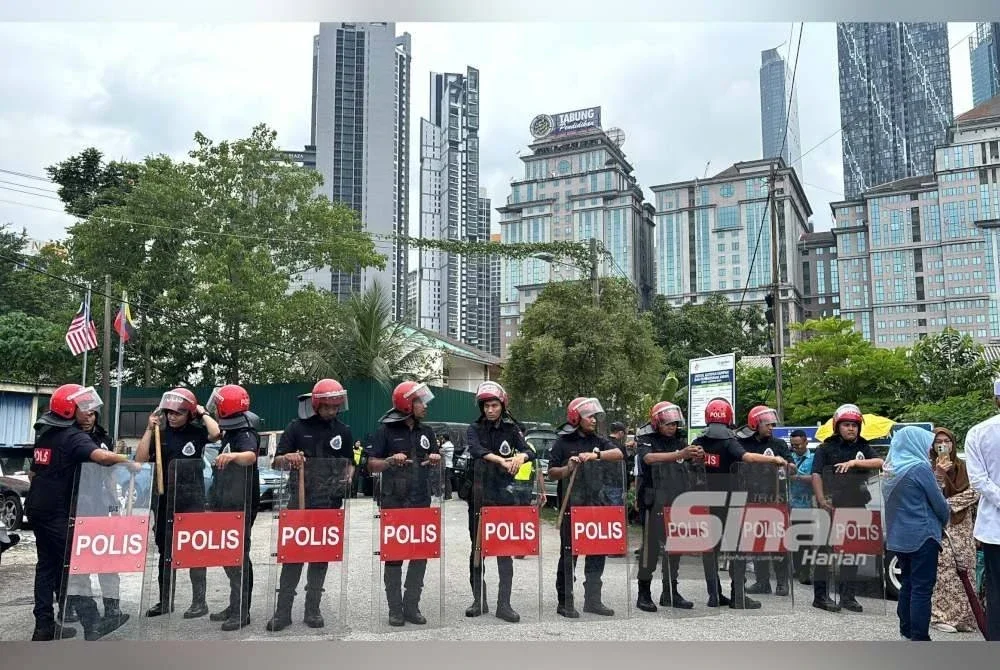 Anggota polis mengawal keadaan di Kampung Sungai Baru pada Khamis.