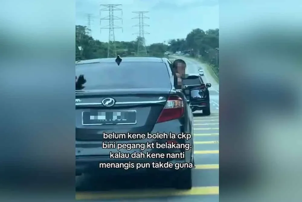 Tangkap layar video tular yang memaparkan dua kanak-kanak menjenguk keluar dari tingkap sebuah kereta sedang bergerak di Jalan Kota Tinggi berhampiran Muzium Kota Tinggi.