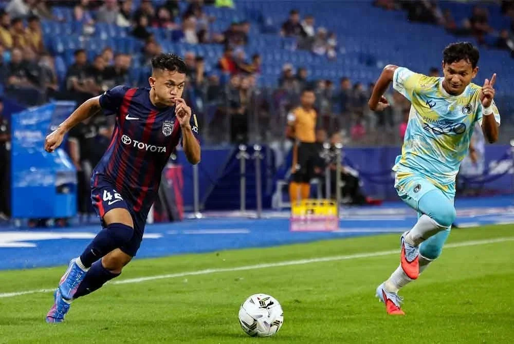 Pemain JDT, Arif Aiman Mohd Hanapi (kiri) melepasi kawalan pemain Penang FC Ahmad Irfan Mohd Noor (kanan) pada perlawanan Liga Super Malaysia 25/26 di Stadium Sultan Ibrahim, pada Khamis. Foto Bernama