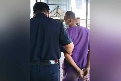 Suspek (kanan) yang ditahan reman selama tujuh hari dibawa keluar dari Mahkamah Sungai Petani pada Khamis.