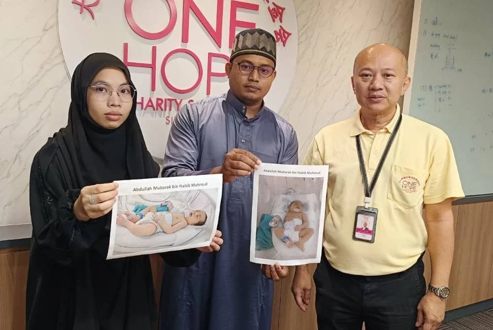 Habib Mahmud (tengah) bersama isterinya menunjukkan gambar bayi mereka ketika mendapatkan bantuan daripada One Hope Charity & Welfare.