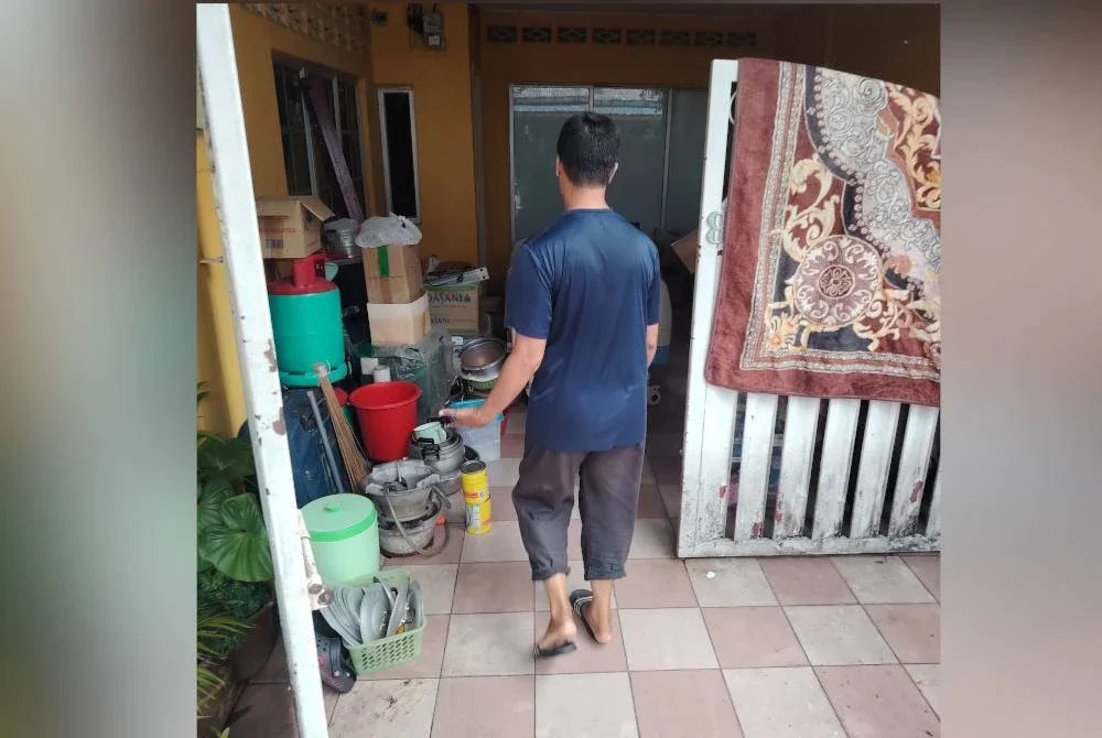 Penduduk Kampung Sungai Baru mengemas barang selepas operasi pengosong kediaman pada Jumaat.