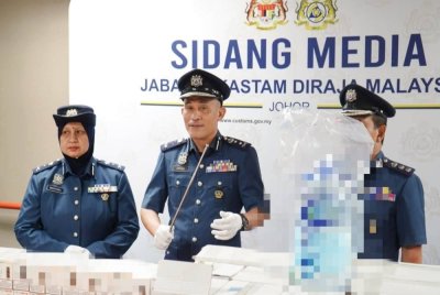 Aminul Izmeer (tengah) menunjukkan air zamzam dan cecair rokok elektronik yang dirampas dengan nilai rampasan keseluruhan termasuk duti serta cukai dianggarkan mencecah RM3.42 juta. Foto JKDM Johor