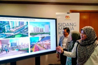 Dr Zaliha (tengah) melihat gambar kawasan pembangunan Kampung Baru Kuala Lumpur.