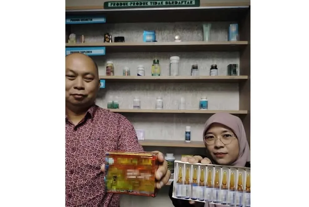 Ibrahim (kiri) dan Ketua Penolong Pengarah Kanan Farmasi, Syuhaida Mohd Yasin menunjukkan antara produk yang dirampas.