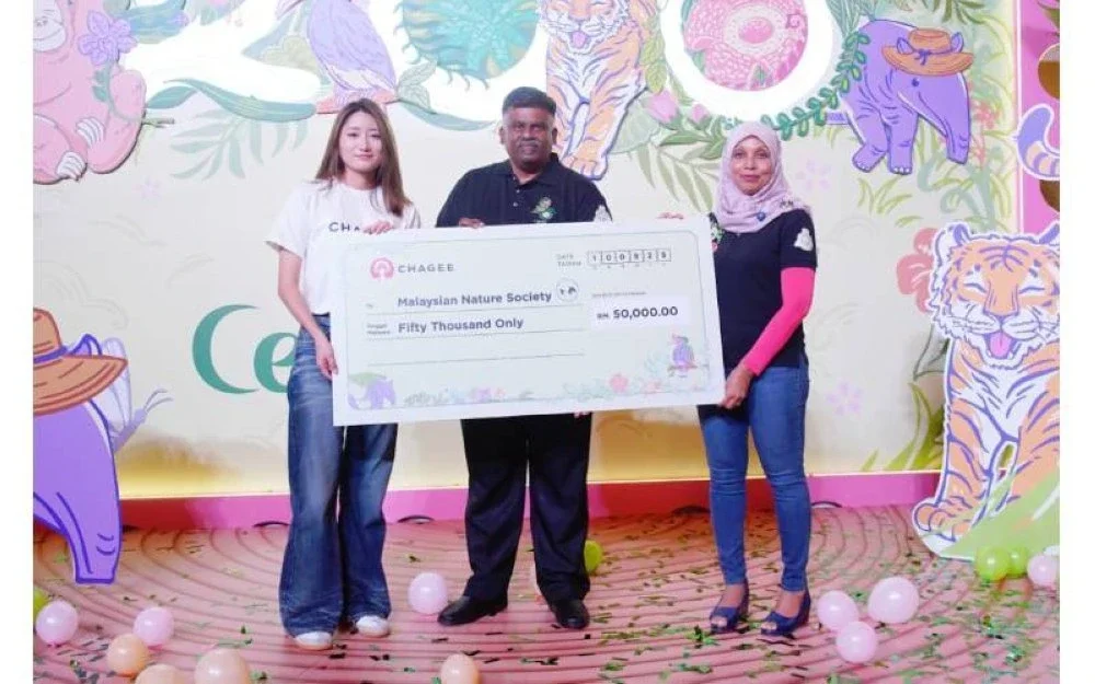 Lucia Guan (kiri) menyerahkan cek cura berjumlah RM50,000 kepada wakil MNS bagi pelaksanaan projek Tapir Food Bank dan Tapir Translocation Box.