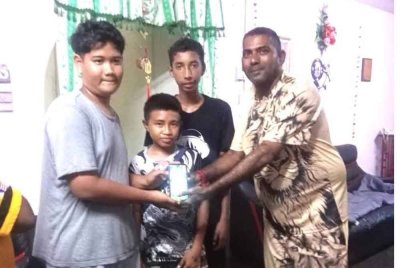 Saravana (kanan) bersama tiga sekawan yang memulangkan telefon bimbit anaknya tercicir sewaktu bersiar di Kampung Pasir Tengah, Rantau.