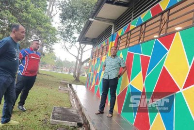 Mohd Helmy (kanan) melihat reka bentuk tandas awam berkenaan.