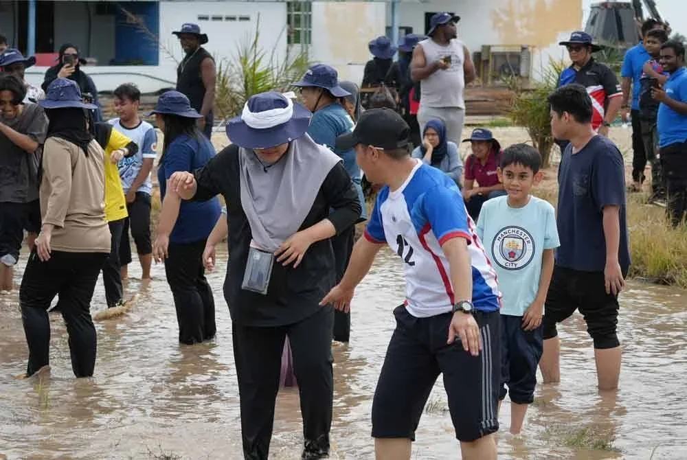 Peserta tidak melepaskan peluang untuk aktiviti menggagau ikan di sawah.