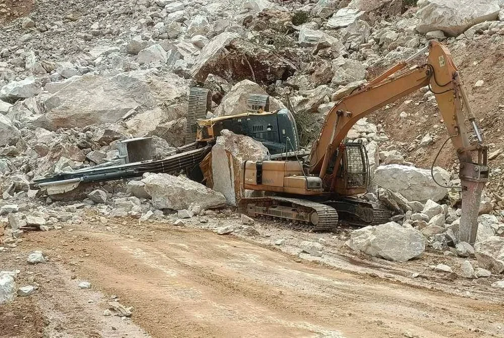 Keadaan salah sebuah jengkaut yang terbalik dipercayai akibat dihempap runtuhan batu di sebuah kuari di Raub pada Sabtu.