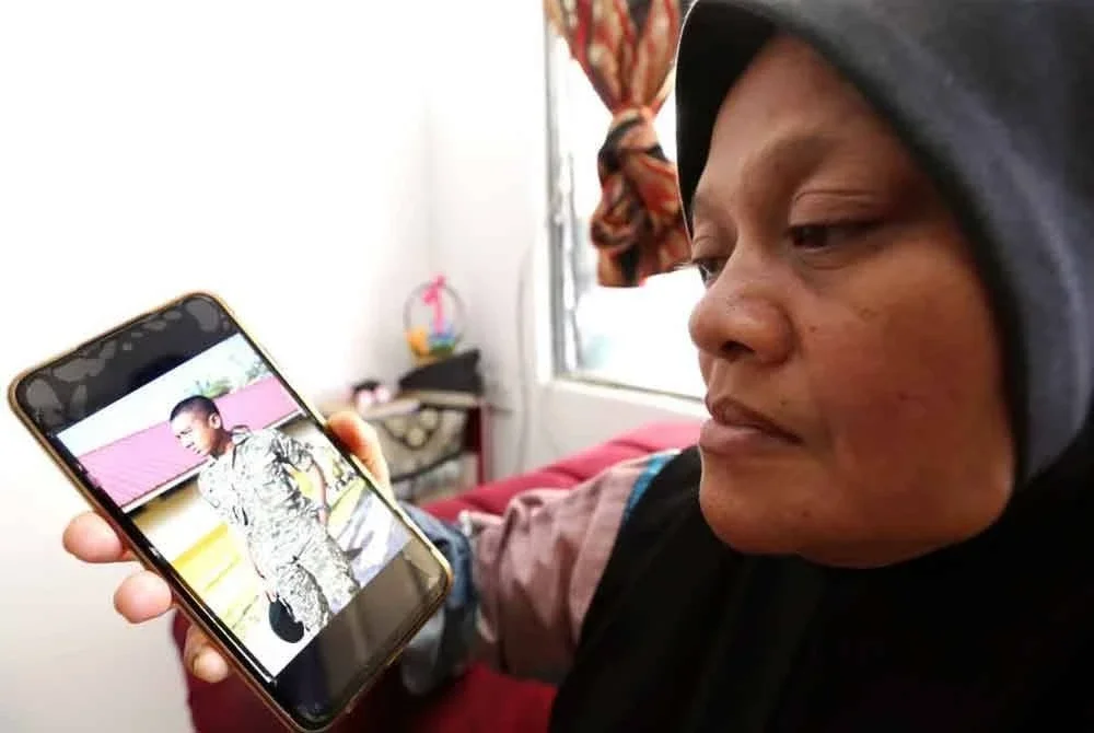 Junaedah menatap gambar kenangan anaknya, Muhammad Irfan Haiqal ketika ditemui di kediamannya pada Ahad.